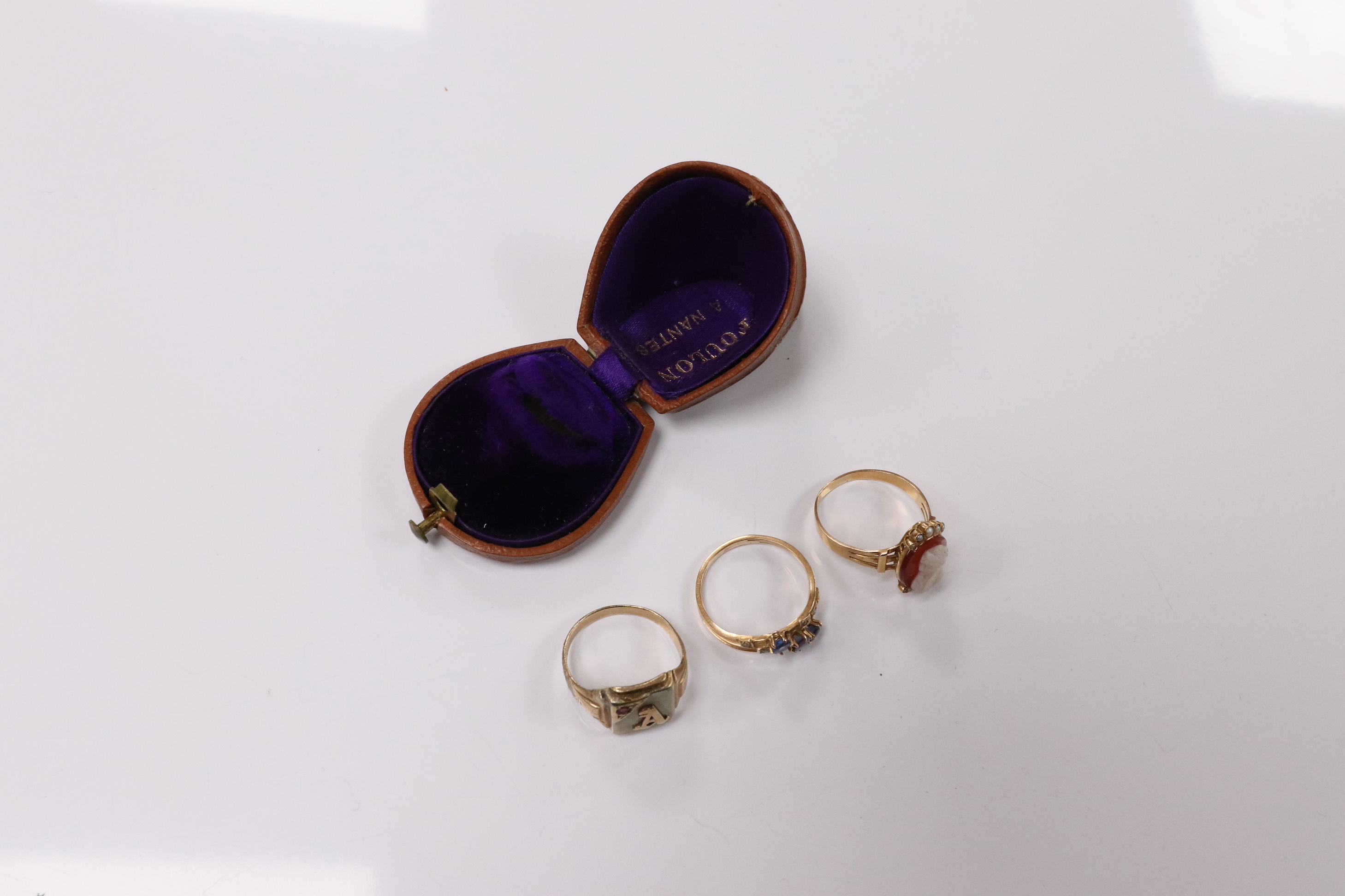 A 10k and gem set initial ring, a continental yellow metal and gem set ring and an early 20th century yellow metal, hardstone cameo and seed pearl set ring, size P, gross weight 8.2 grams. Condition - poor to fair